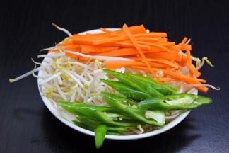 豆芽洗净，胡萝卜去皮切丝，辣椒洗净切好待用；