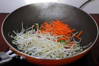 辣椒、豆芽、胡萝卜倒入锅中爆炒；