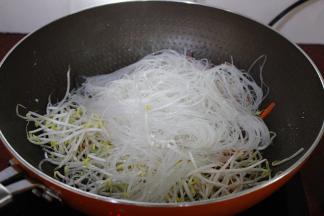 加入粉丝继续炒至八成熟；PS：要粉丝在上面，这样就不粘锅。