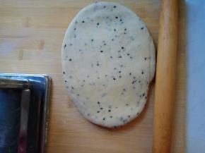 饧好的面团按扁，用擀面杖粗略擀成牛舌状。