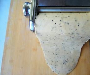 把面片一端平整放入压面机齿槽中，用1档旋钮，面片厚度约5毫米。