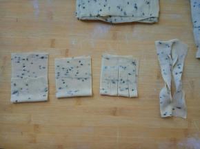 以单片演示：
从下端向上轻对折，不要折实，在折痕处，顺纵向方向切三刀。拎起面片一端，穿过中间的刀口，整理好。