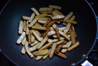 热油锅，先放香干煸至切口也变焦黄盛出待用