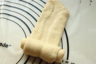 取一份面团，擀开，两边折上去再擀平，然后再卷起来