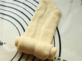 取一份面团，擀开，两边折上去再擀平，然后再卷起来