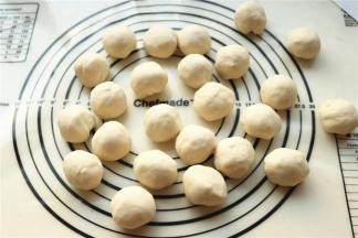 醒发之后面团会柔软很多，再次揉光滑，分成24个小面团，每个大约25克。