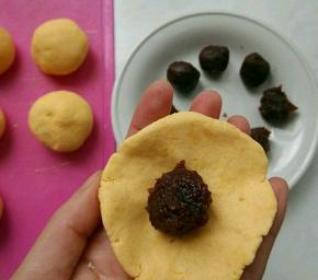 将小面剂用手按成边缘薄，中间厚的圆片，包入红豆沙。