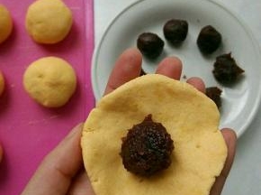 将小面剂用手按成边缘薄，中间厚的圆片，包入红豆沙。