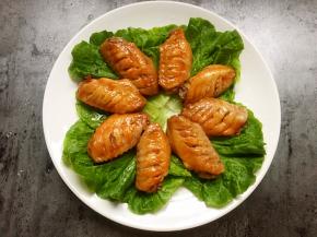 将鸡翅摆在生菜上。