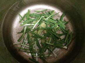 在高压锅底部铺上姜片、葱段和香料。