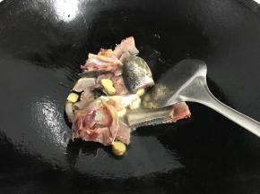 放入鱼头和鱼尾翻炒。