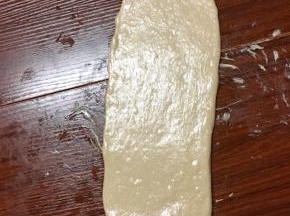 取一个松弛好的面团，光面朝下擀成椭圆
