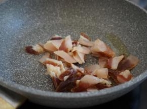 锅加8克油烧热，倒入腊肉片，快速翻炒