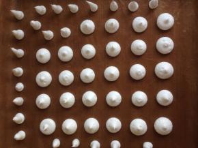 将蛋白霜挤到铺了高温油布的烤盘上，挤出圆形和上面尖尖的蘑菇柄