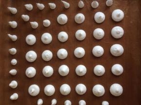 将蛋白霜挤到铺了高温油布的烤盘上，挤出圆形和上面尖尖的蘑菇柄