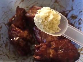 放入一勺鸡精，将大蒜去皮洗尽切碎放入，搅拌均匀腌制2小时