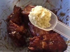 放入一勺鸡精，将大蒜去皮洗尽切碎放入，搅拌均匀腌制2小时