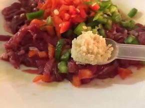 将红椒，青椒洗净后切碎放入，放一勺鸡精，少许盐，适量植物油拌匀腌制一个小时