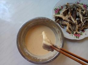 夹一叶蘑菇，裹匀蛋糊，抖掉多余的糊糊。
此时，考验面糊调制的状态了：面糊太稀，挂不住浆；太浓稠，口感会太厚实不酥脆。