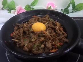 立刻盖上锅盖，焖5分钟，牛肉变色将鸡蛋打入淋上调味料。