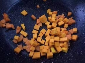 将南瓜洗净去皮切丁放入锅中翻炒变色
