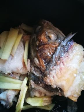 一面煎得焦黄后，翻面，煎另一面，放入生姜片