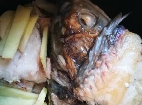 一面煎得焦黄后，翻面，煎另一面，放入生姜片