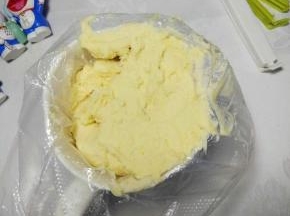 把混合均匀的曲奇面团装入裱花袋，用封口夹把裱花袋口后面夹住；