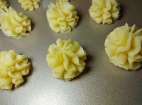 烤盘铺油纸或者油布（也可以用金盘或者马卡龙烤盘，不粘可以不铺油纸）挤曲奇花。裱花嘴与烤盘成90度垂直，左右晃动裱花袋的同时向上提。每个曲奇挤4--6层花纹；