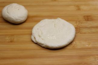 卷紧的面团切开分4份，横切好的面团，二头捏紧口，再次擀开；