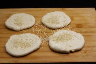 擀好的面团，撒上芝麻，压紧实；