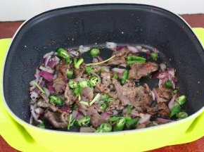 腌制好的牛肉，放入锅中爆炒，加上洋葱、辣椒、香葱、等福利爆炒至熟，起锅。