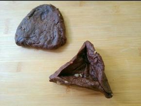 取一个剂子，用手整理成三角形，用包糖三角的手法，三边捏住且捏紧。