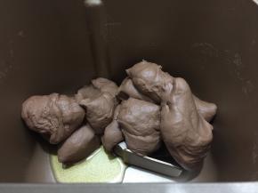 拿出用刮板切成块状再投入面包机桶内，加入橄榄油继续揉