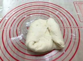拿出面团在垫子上撒上些许面粉继续揉面