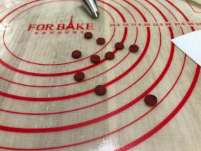 剩下的红曲小面团擀开，用裱花嘴按压出小圆片