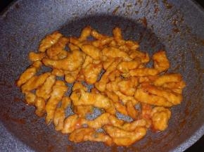 倒入炸好的里脊肉迅速翻拌，均匀裹上酱汁。关火，撒上葱花出锅装盘。