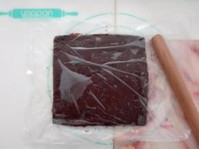 巧克力糊稍微放凉后倒在保鲜膜上，上面覆盖一层保鲜膜，擀成约20CM的方片，入冰箱冷冻。