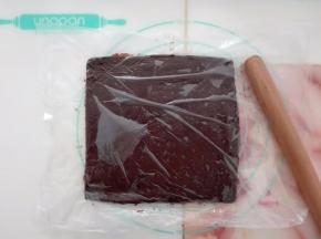 巧克力糊稍微放凉后倒在保鲜膜上，上面覆盖一层保鲜膜，擀成约20CM的方片，入冰箱冷冻。