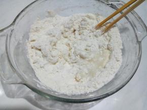 面粉分次浇入滚开的水，用筷子搅成絮状。