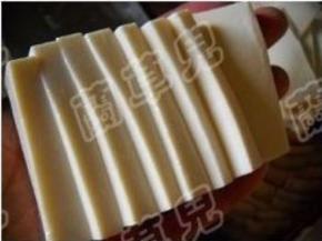 嫩豆腐用水冲一下，切下边皮；片成9片。