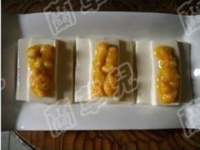 裹好蛋黄的鱼肉粒，放在蒸好的豆腐上。