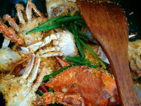 加入葱段炒至面包糠、蒜末裹在蟹块上为止 