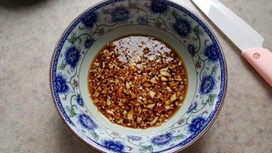 8.言归正传把蒜末放在容器中，加入盐，糖，醋和酱油（可以倒入适量凉开水）。