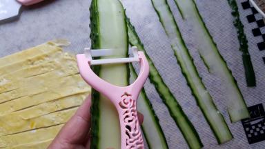 5.把黄瓜洗净，用奈瓷刮刀刮黄瓜片，刮出的黄瓜片薄厚均匀表面光滑且抗氧化能力非常强，黄瓜片放很久也不会有发黄变色的情况，大爱呀，吐槽一下以前的刮刀，刮出的黄瓜片比较厚且不均匀，还会使黄瓜片氧化，编出的菠萝皮颜色也不好看，奈瓷套刀把全部的问题都解决了。