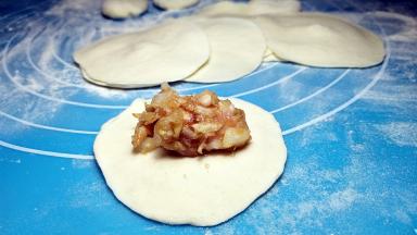 取适量肉馅放入中间。