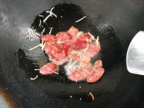 倒入腊肠，煸炒出油。