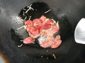 倒入腊肠，煸炒出油。