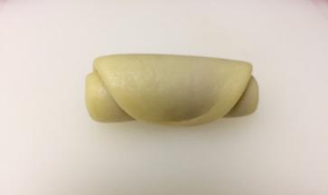 从一端至另一端卷起，盖上保鲜膜静置15分钟，依次做好剩下的九份。然后重复上述步骤，再一次将卷起的面团压扁，擀成牛舌状然后卷起，静置15分钟。面团静置的同时，我们可以分割馅料，我做的是大个的蛋黄酥，每份90几克重，馅料大约是35g一个。把冷却后的蛋黄包入l分好的豆沙馅中，备用。