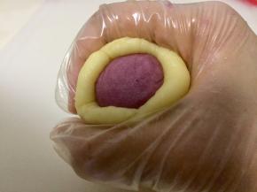 静置好的油皮和油酥面团分别均匀分成十等份，取一个油皮面团擀成薄片，放入油酥面团，然后用虎口收紧。